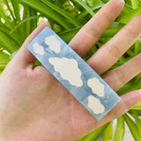 A hand holding the barrette, showcasing its size and design.