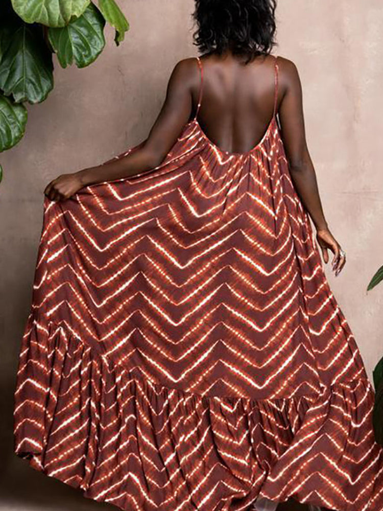Back view of a woman wearing a brown and white tie-dye print maxi dress with spaghetti straps and a low back, showing the flowing skirt.