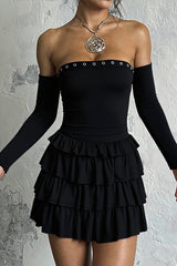 Model wearing a black off-the-shoulder dress with long sleeves and a ruffled skirt.