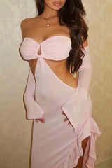 Front view of a woman in a pink jersey knit dress with a ruffled hem