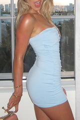 side view of a woman wearing a light blue ruched strapless mini dress