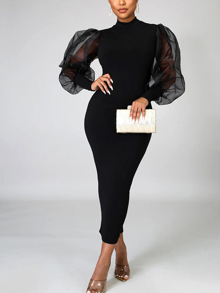 Full body shot of a woman in a black bodycon dress with voluminous sheer sleeves.