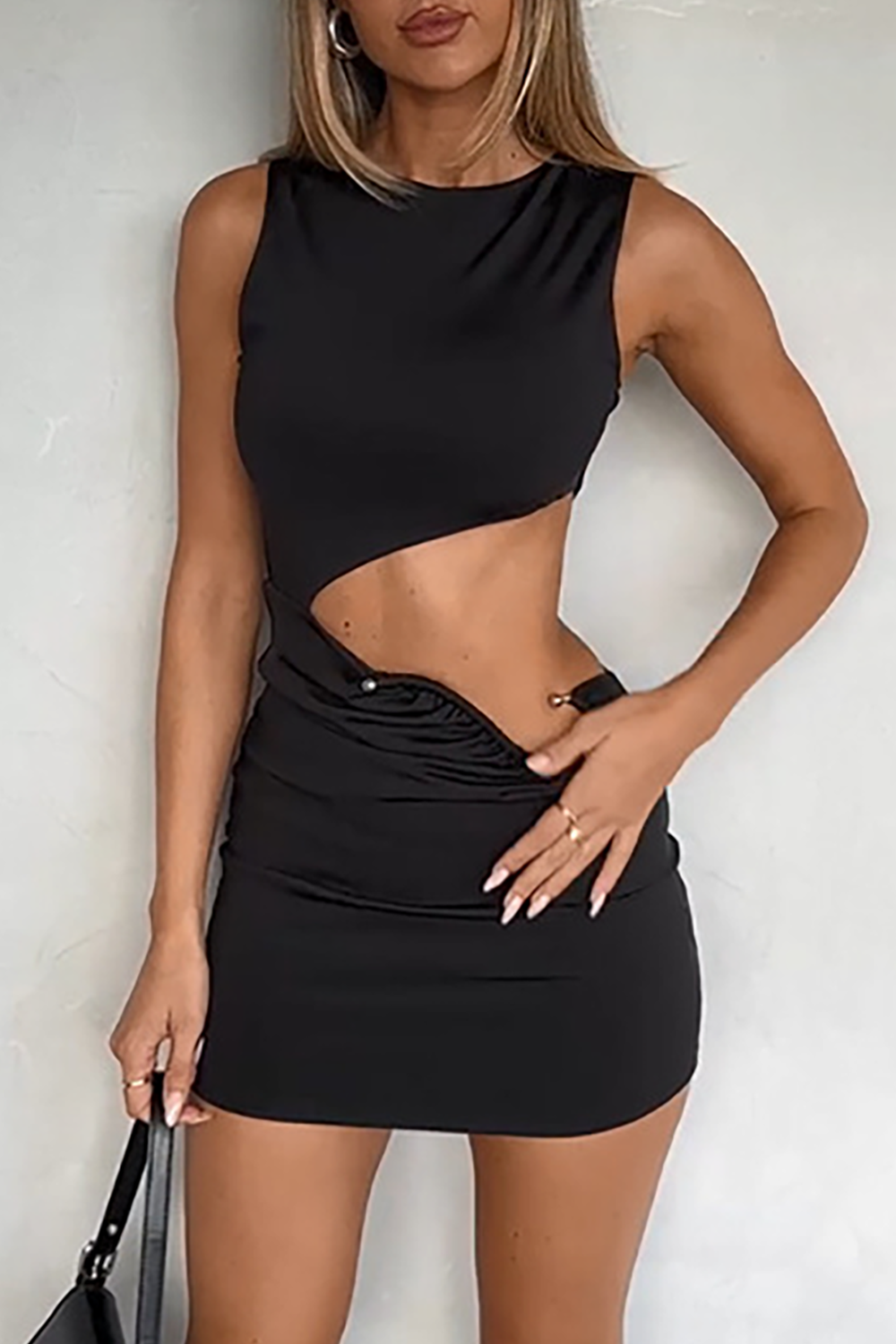 Woman wearing a black sleeveless round neck mini dress with side cut-outs and ruched detailing.