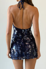 woman wearing a navy blue sequined halter mini dress from the back