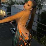 Woman from behind in a bodycon dress with a flame print and a low back, on a balcony.
