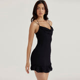 Side view of a woman in a black mini dress with spaghetti straps and a ruffle hem.