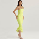 side view of a woman wearing a lime green feather-trimmed dress