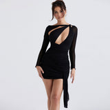 Woman wearing a black long-sleeve mini dress with an asymmetrical neckline and cut-out detail.