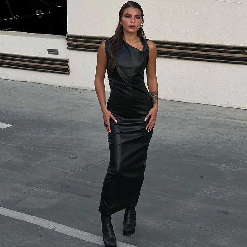 woman wearing a black faux leather column dress with an asymmetrical neckline and ruching detail