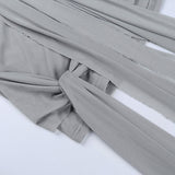 Close-up of the draped fabric and knot detail on the grey dress.
