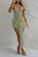 Woman wearing a light green lace corset dress with a draped skirt