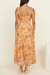 back view of a woman wearing a floral print midi dress with a smocked back detail