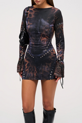 Side profile of a woman in a printed mini dress and black boots