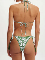 Back view of a white bikini with a green ornate pattern and green tassels.