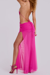 Close-up of the bodice of a pink sheer mesh maxi dress, highlighting the plunging neckline and draped fabric.
