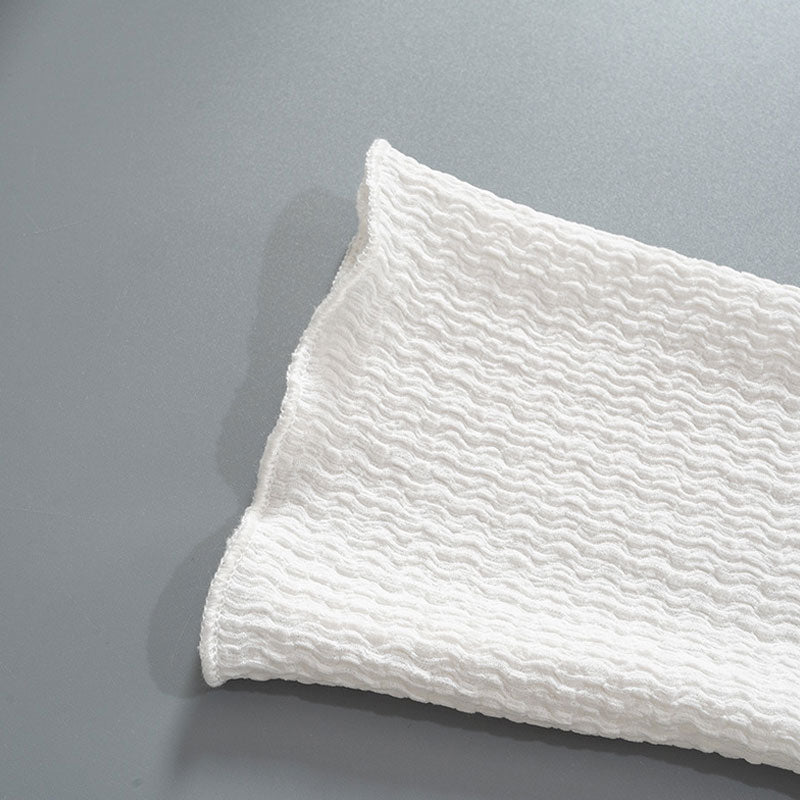 Close-up of white textured crinkle knit fabric with a wavy pattern.