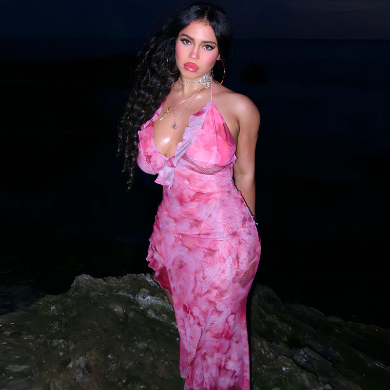 woman in pink floral print halter maxi dress standing on rocks at night