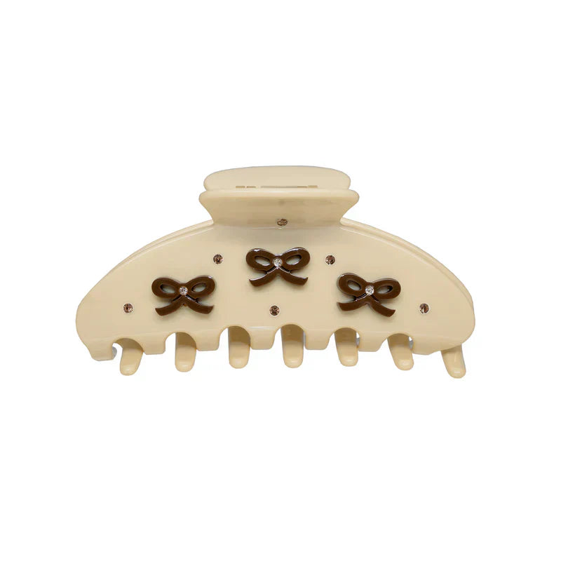 Cream colored claw clip with three brown bow accents and small clear rhinestones