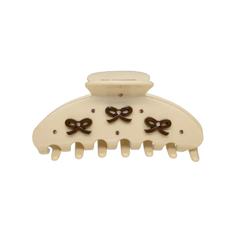 Cream colored claw clip with three brown bow accents and small clear rhinestones