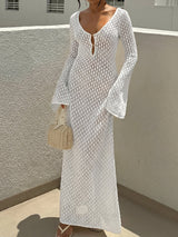 Woman wearing a white crocheted maxi dress with bell sleeves and a deep V-neckline.