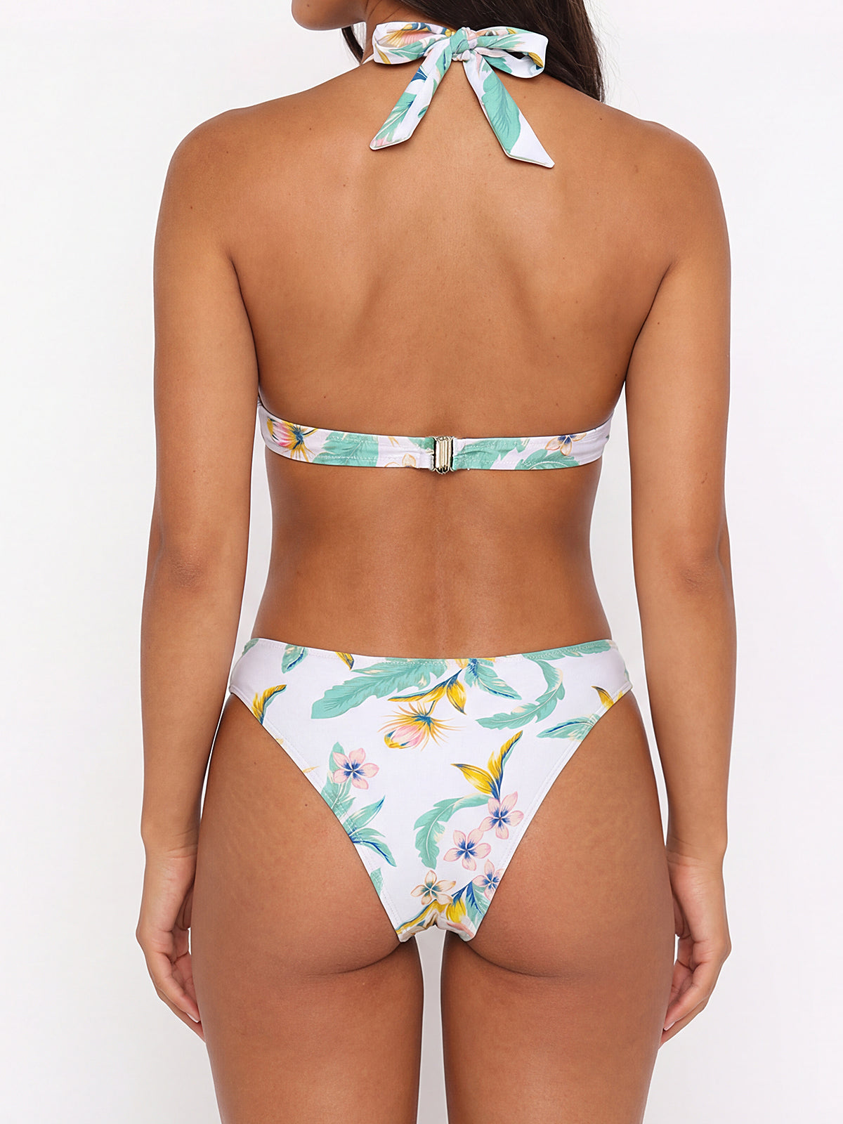 Woman wearing a white bikini with a floral print, side view
