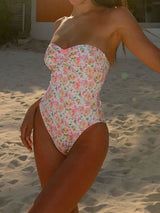 Woman wearing a floral print strapless one-piece swimsuit on the beach