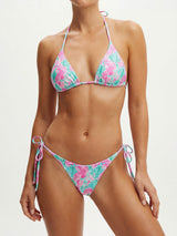 Front view of a woman wearing a pink and teal shell print triangle bikini top with halter neck ties.