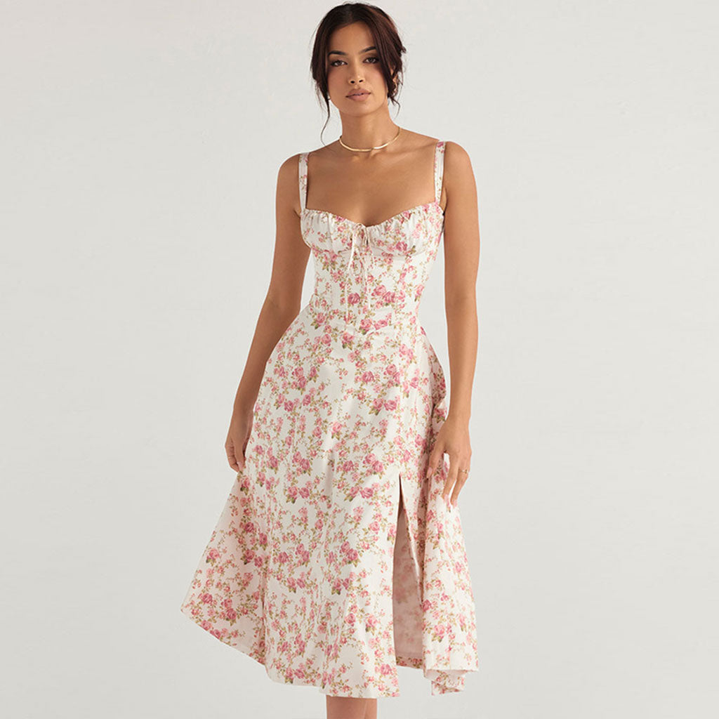 Woman in a white floral print midi dress with a side slit, standing and looking forward.