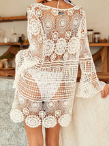 Back view of a woman wearing a white crochet knit tunic over a bikini