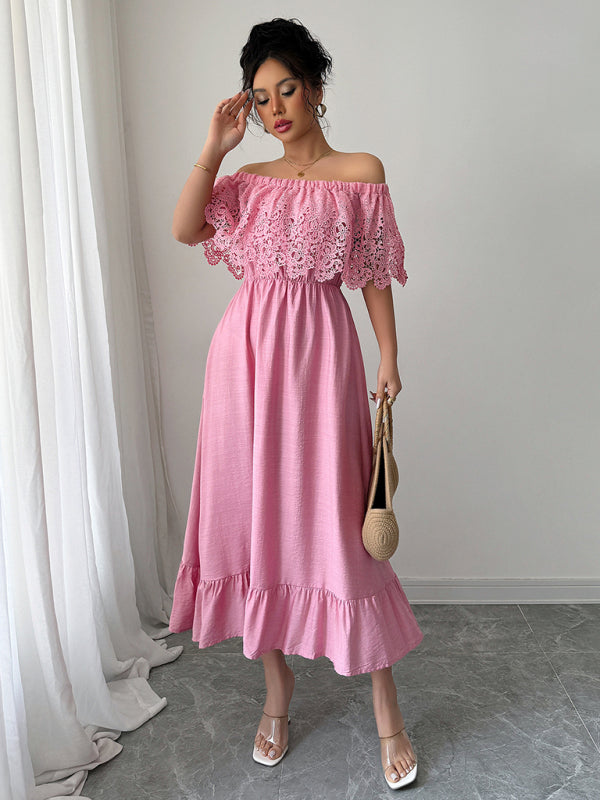 Woman wearing a pink off-the-shoulder maxi dress with lace bodice and ruffled hem, holding a straw bag, front view