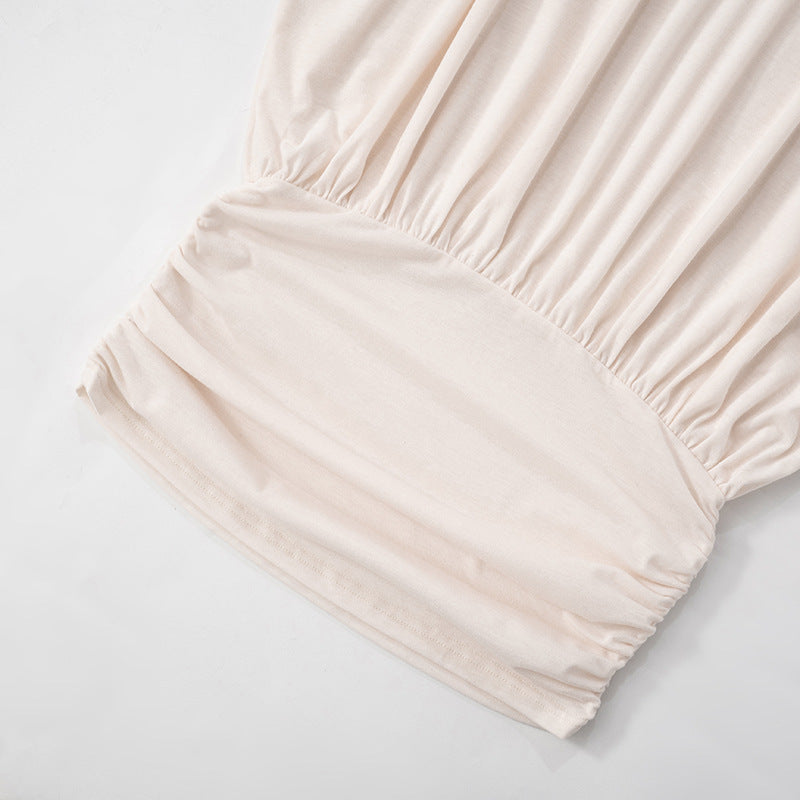 Detail of the ruched elastic waistband on the off-the-shoulder mini dress.