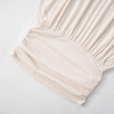 Detail of the ruched elastic waistband on the off-the-shoulder mini dress.