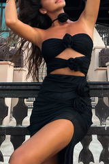 Close-up of a woman in a black evening dress with a cutout and rose details.