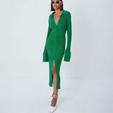 Woman wearing a green ribbed knit midi dress with a collared neckline, button-down front, and high slit, paired with white heels.