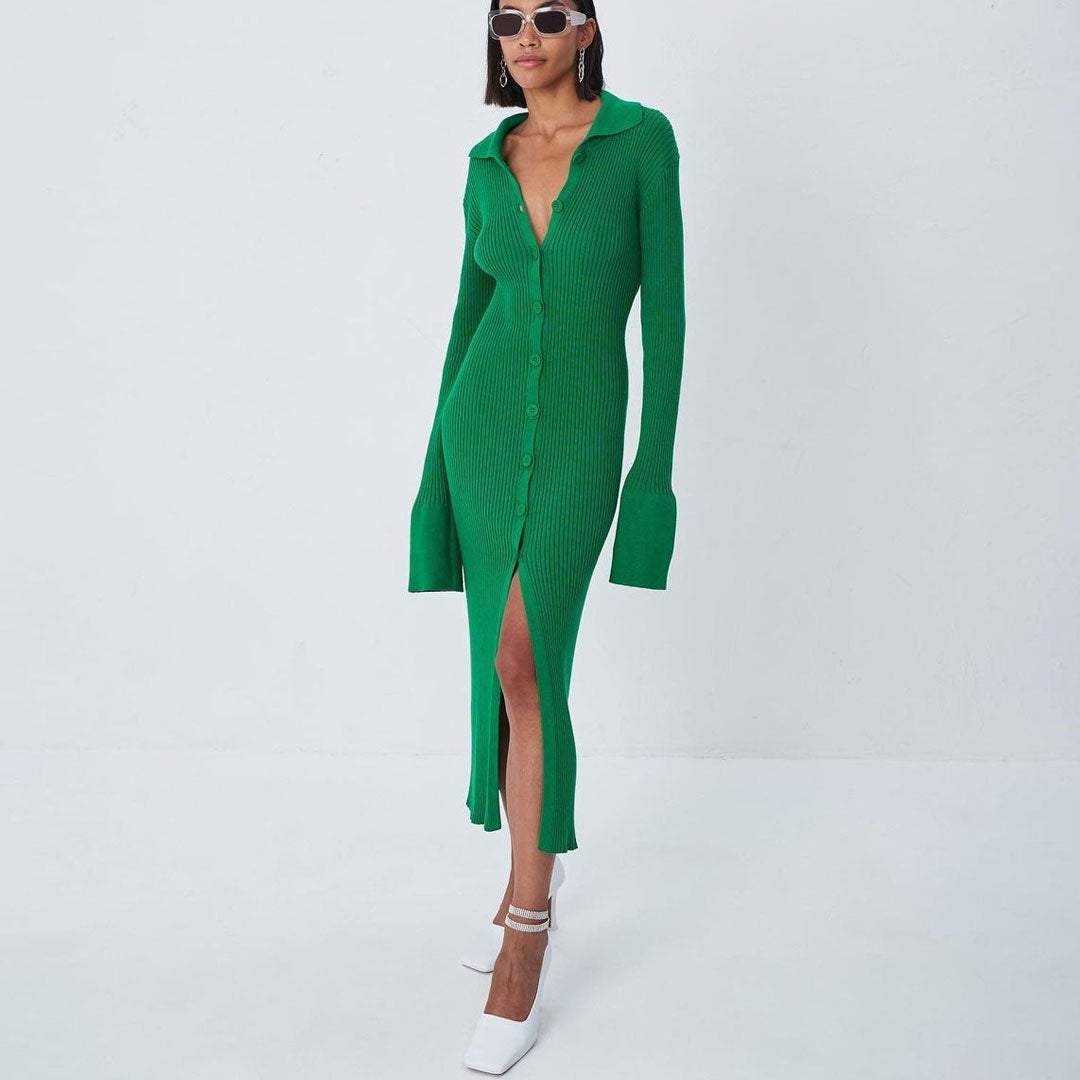 Woman wearing a long-sleeved green ribbed knit midi dress with a collared neckline and a high slit, paired with white pointed-toe heels and sunglasses.