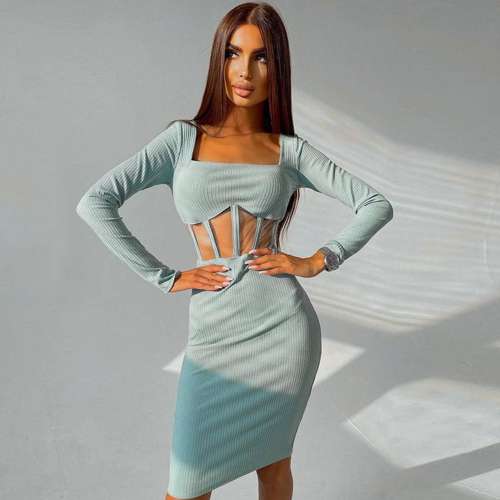 Woman wearing a light blue ribbed knit midi dress with long sleeves and a square neckline, featuring sheer paneling at the waist.