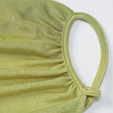 Close-up of the ruched detail on the shoulder strap of a lime green dress.