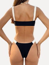 Model wearing a black and white bikini set with ruched straps from the back.