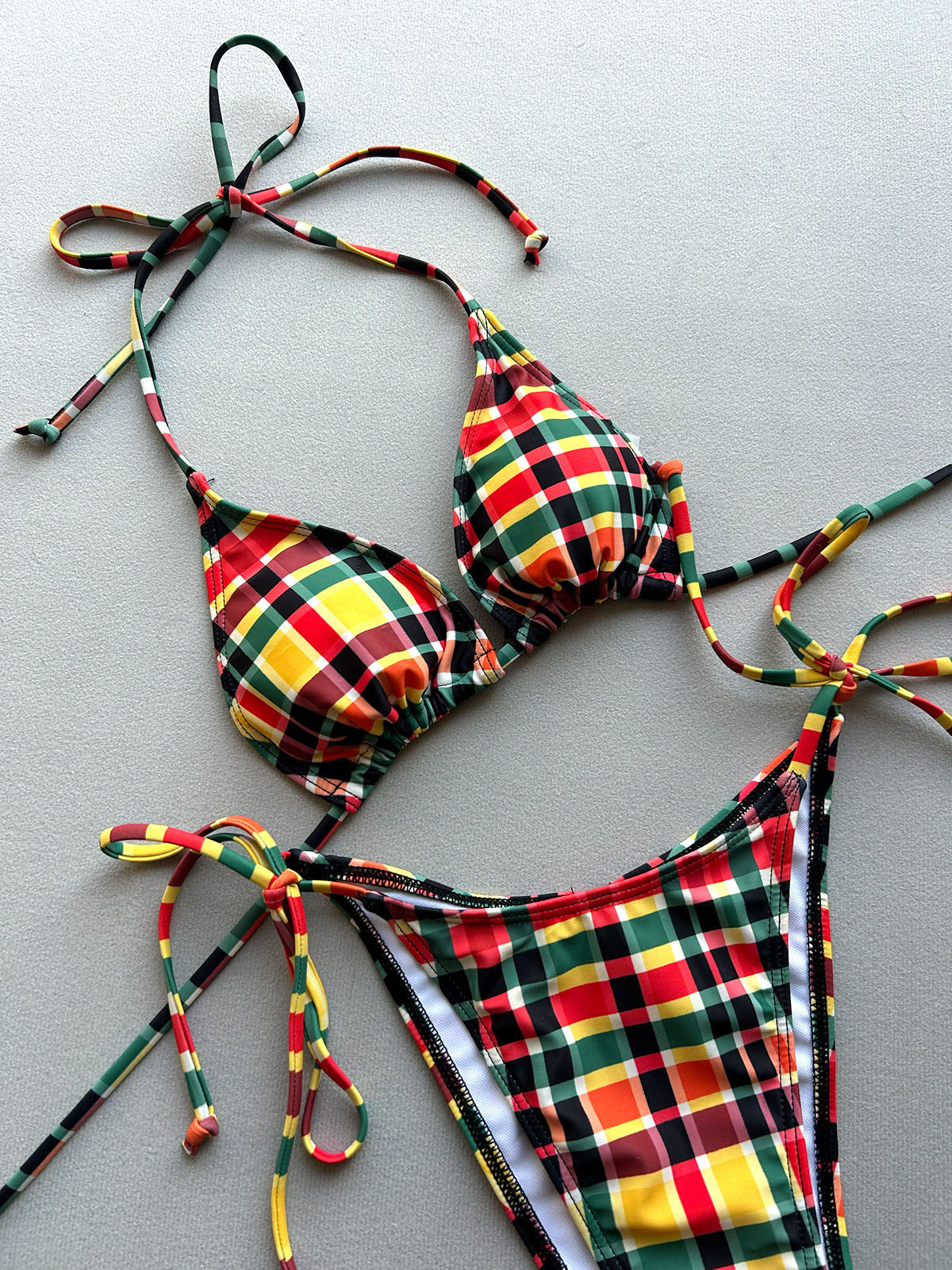 Tartan plaid bikini set laid flat on a grey surface