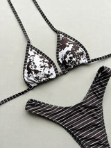 Flat lay of a triangle bikini top with a brown and white abstract print and contrast trim.