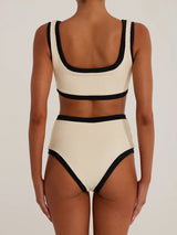 Woman wearing a cream and black ribbed bikini set, back view.