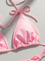Close-up of a pink ruched bikini top with adjustable ties.