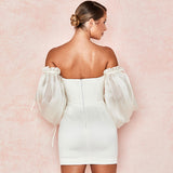 Back view of a white off-the-shoulder mini dress with a zippered back and sheer sleeves