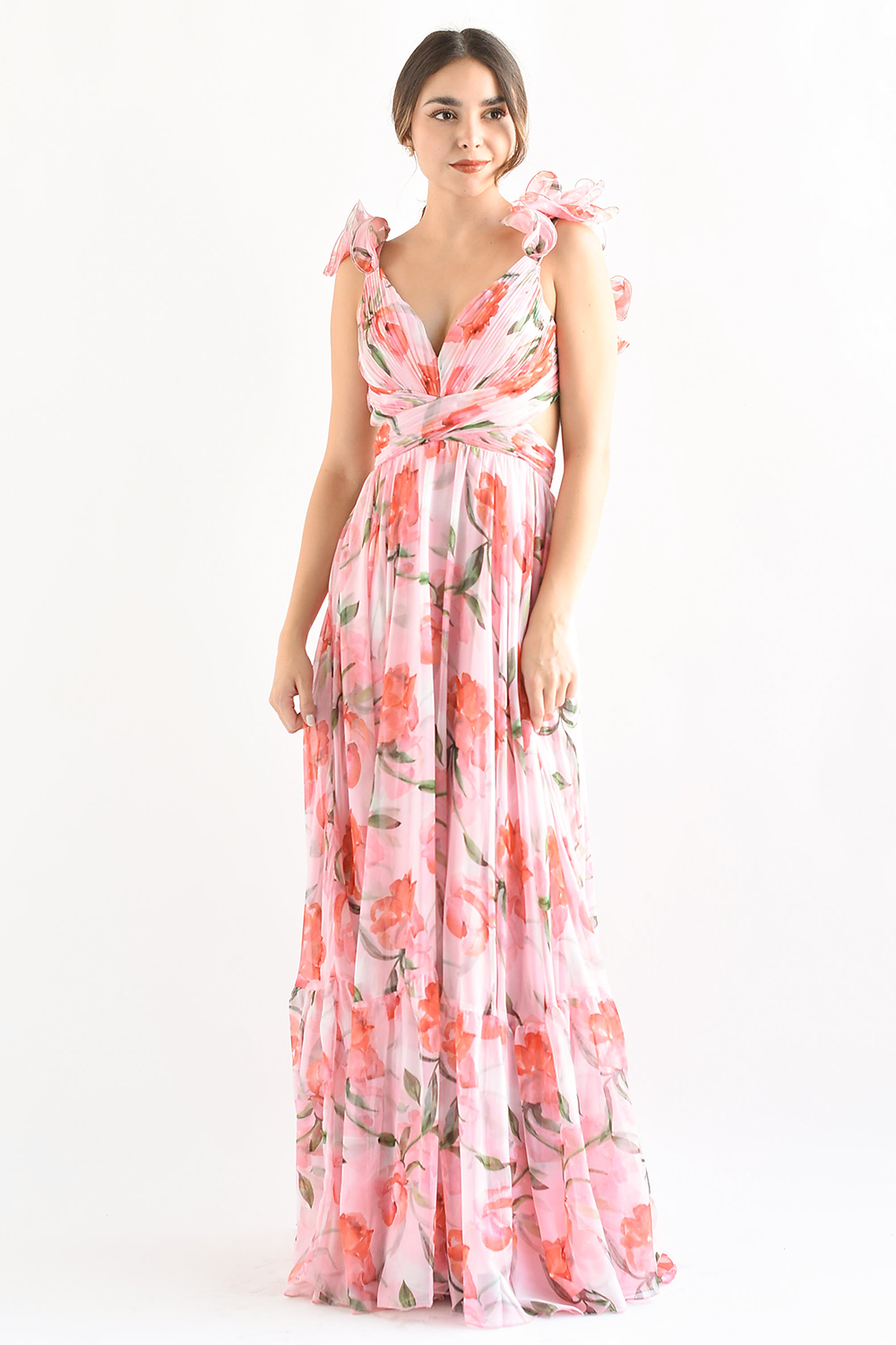 Full-length view of a woman in a pink floral print maxi dress with ruffled shoulder straps and a cinched waist.
