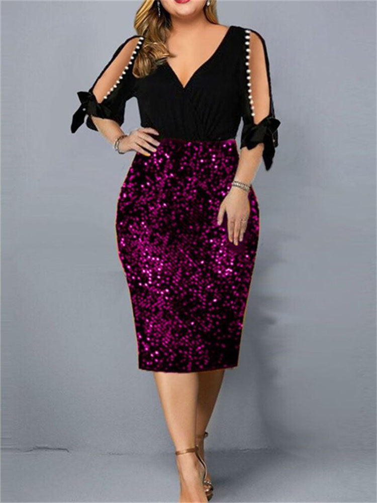 Woman wearing a black and fuchsia sequined sheath dress with cold shoulder sleeves and pearl accents