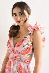 Close-up of the bodice of a pink floral print maxi dress, highlighting the plunging neckline, ruffled shoulder straps, and cut-out sides.