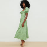Side profile of a woman modeling a green floral print midi dress.