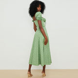 Rear view of a woman in a green floral print midi dress.