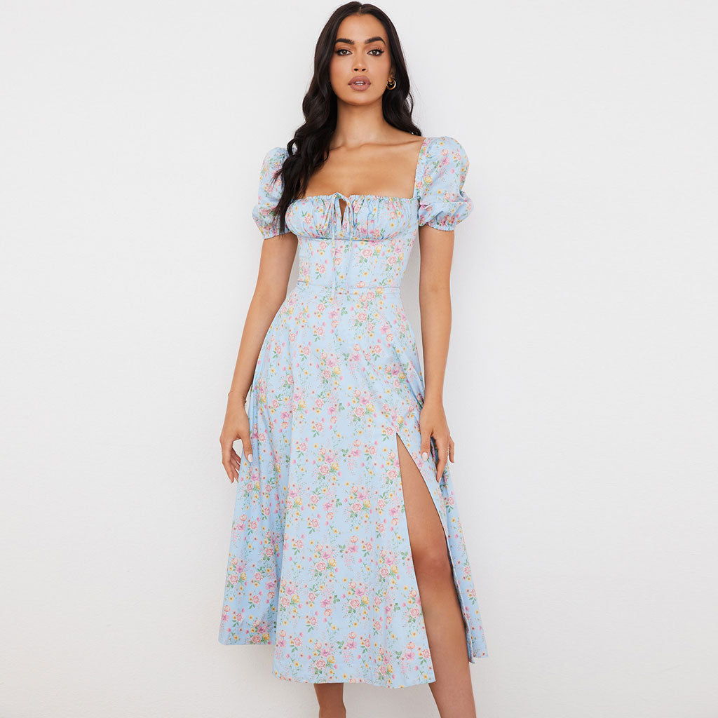 Front view of a woman in a light blue floral midi dress with a square neckline and puff sleeves.