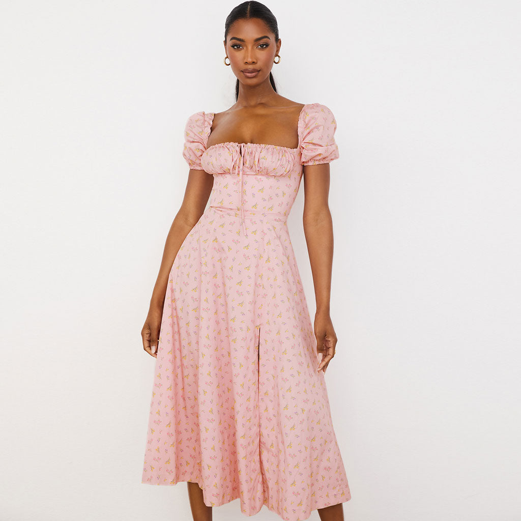 woman wearing a pink floral midi dress with puff sleeves